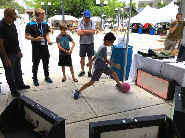 Kid kicking ball at skill court