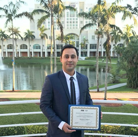 Photo of Mohsen Taheri holding his awarded UGS Provost Award for Graduate Student Engagement